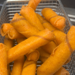 Gefrituurde kaasstengels in een friet mandje in de hapjeskar